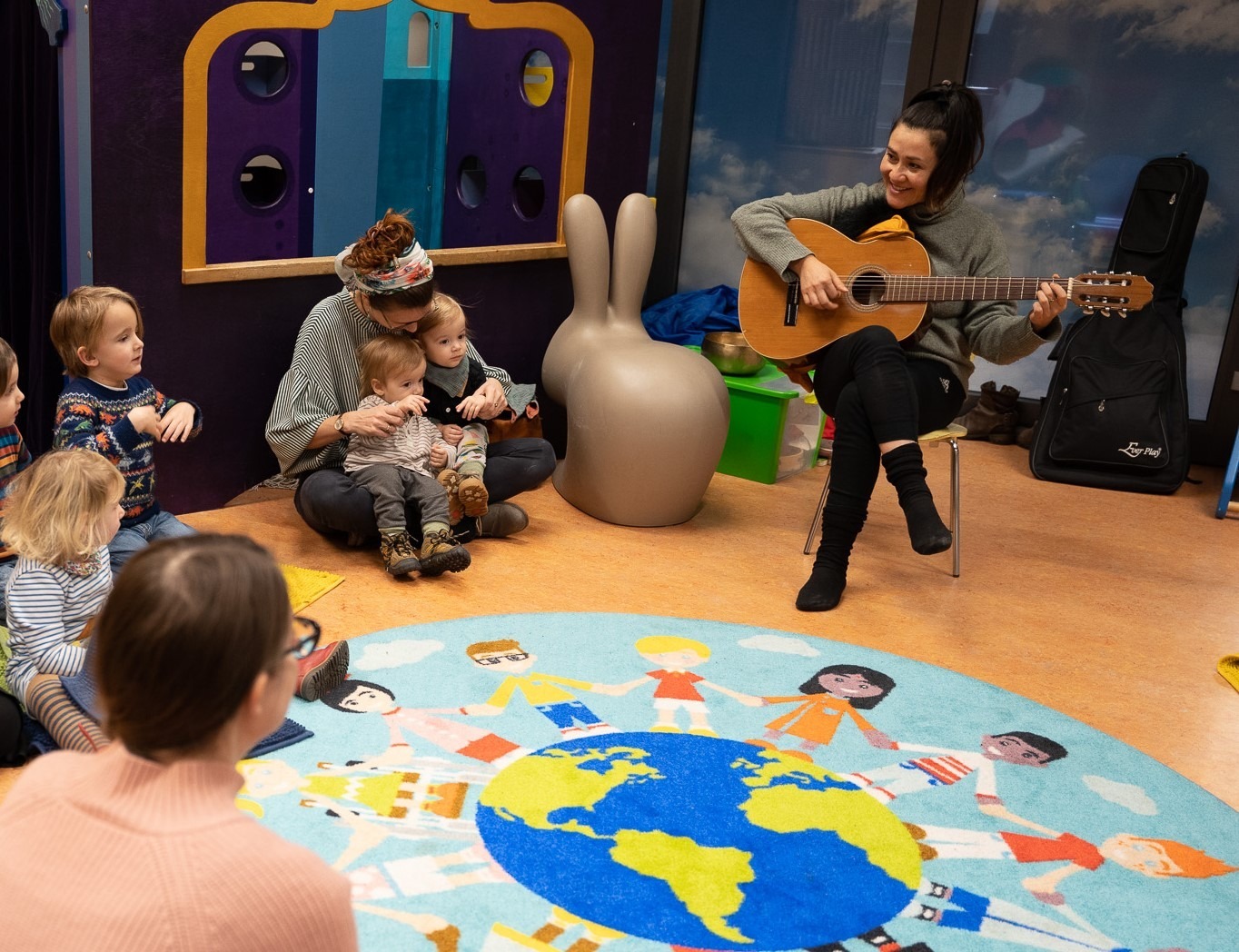 Kinder und Eltern singend im Sitzkreis