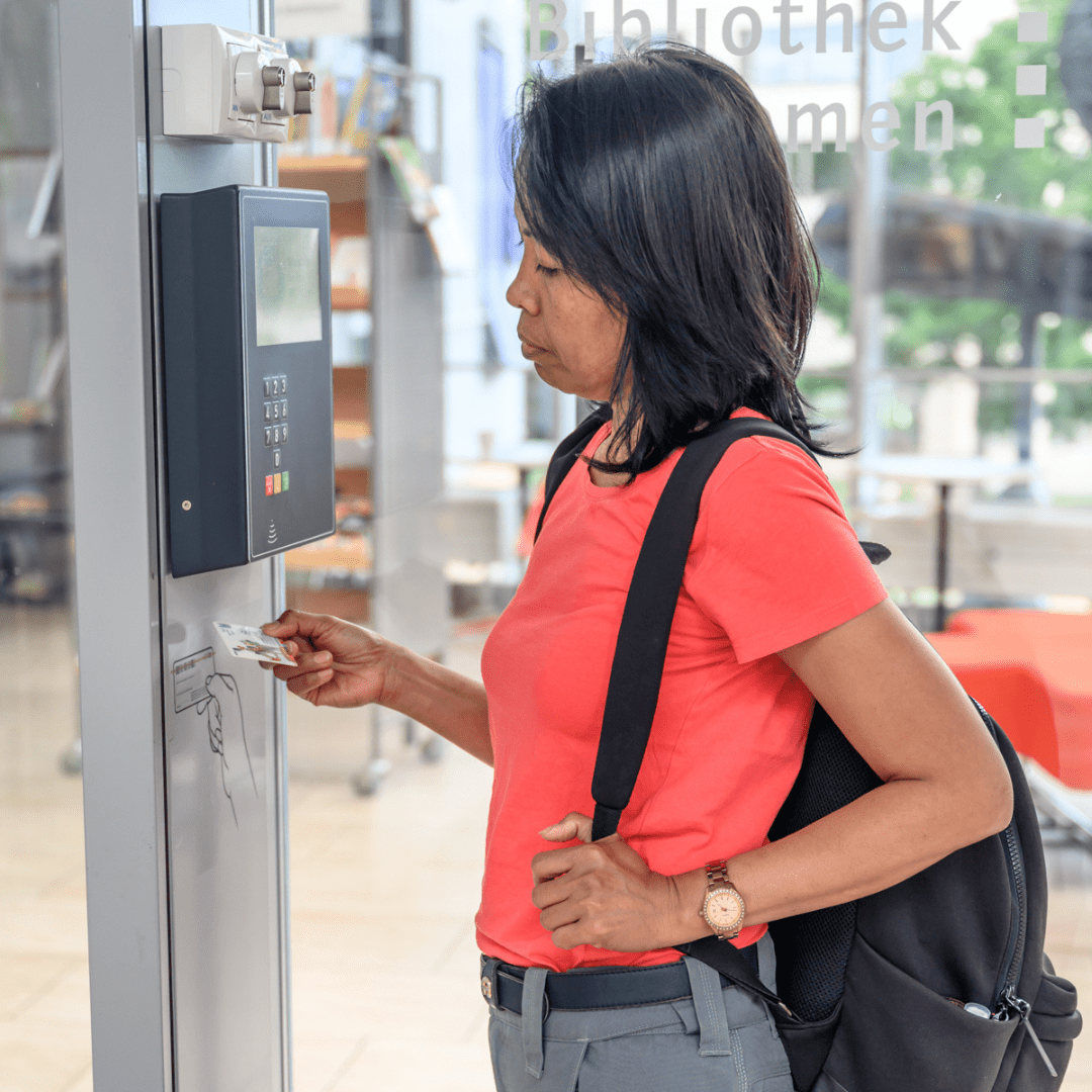 Eine Frau scannt eine Bibcard am Open Library Terminal