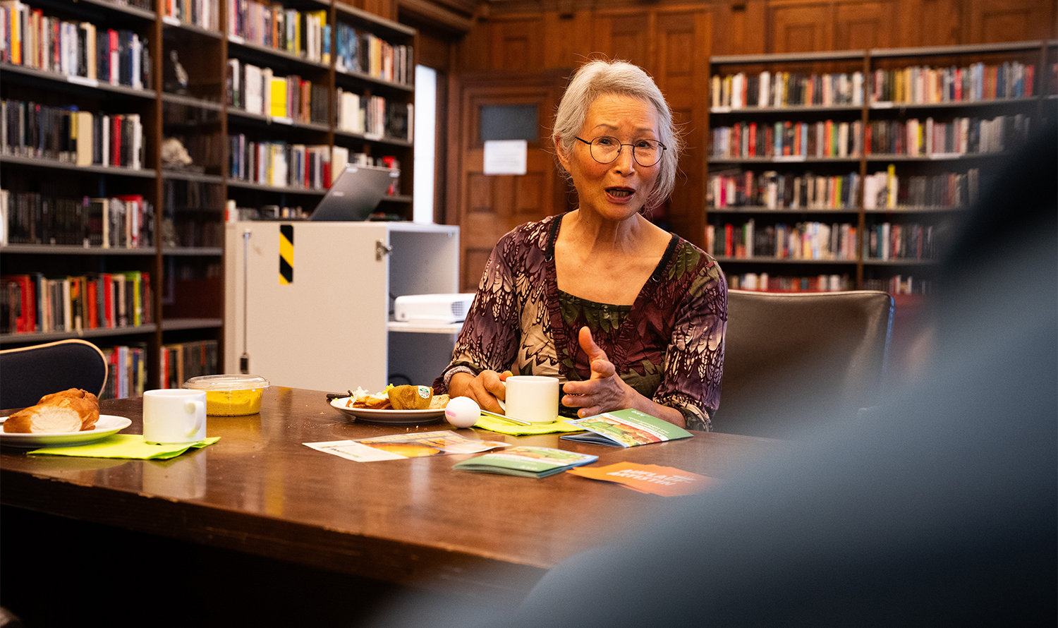 A woman drinks coffee in the crime library.