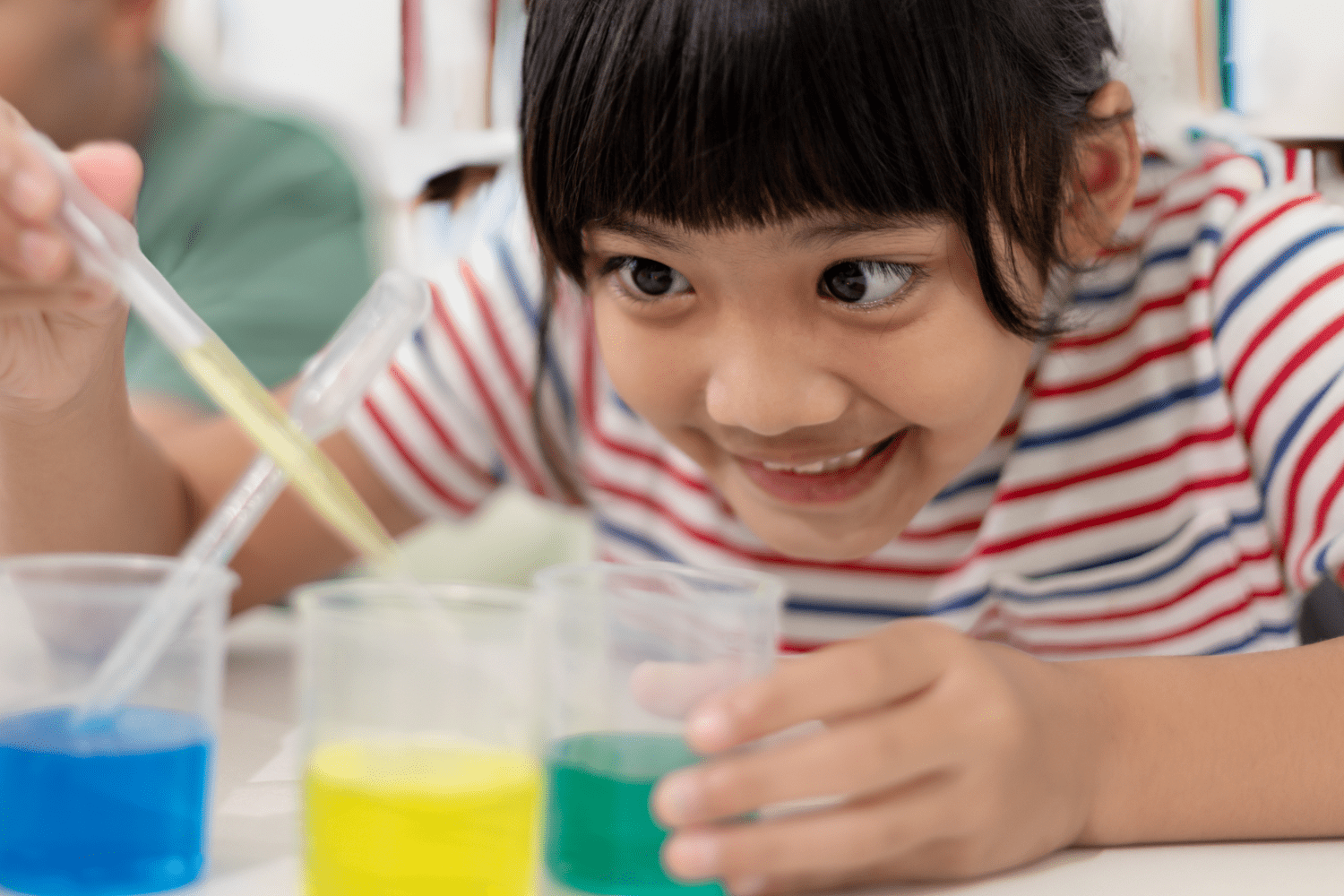 A girl experiments with colorful liquids.