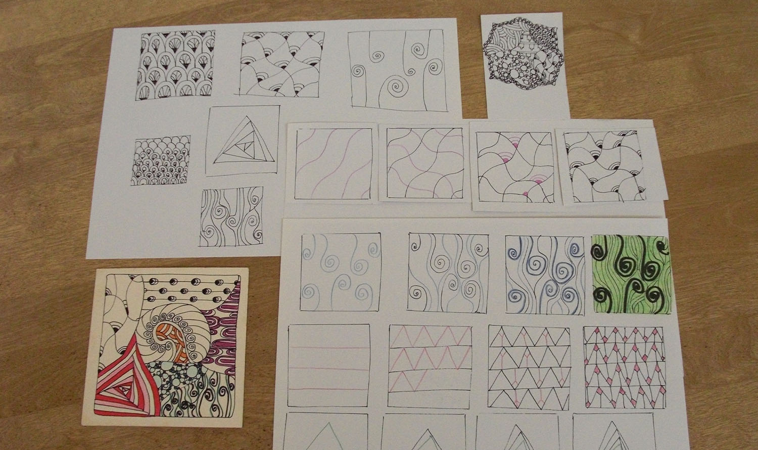 Na stole znajdują się różne kreatywne wzory (Zendoodles).