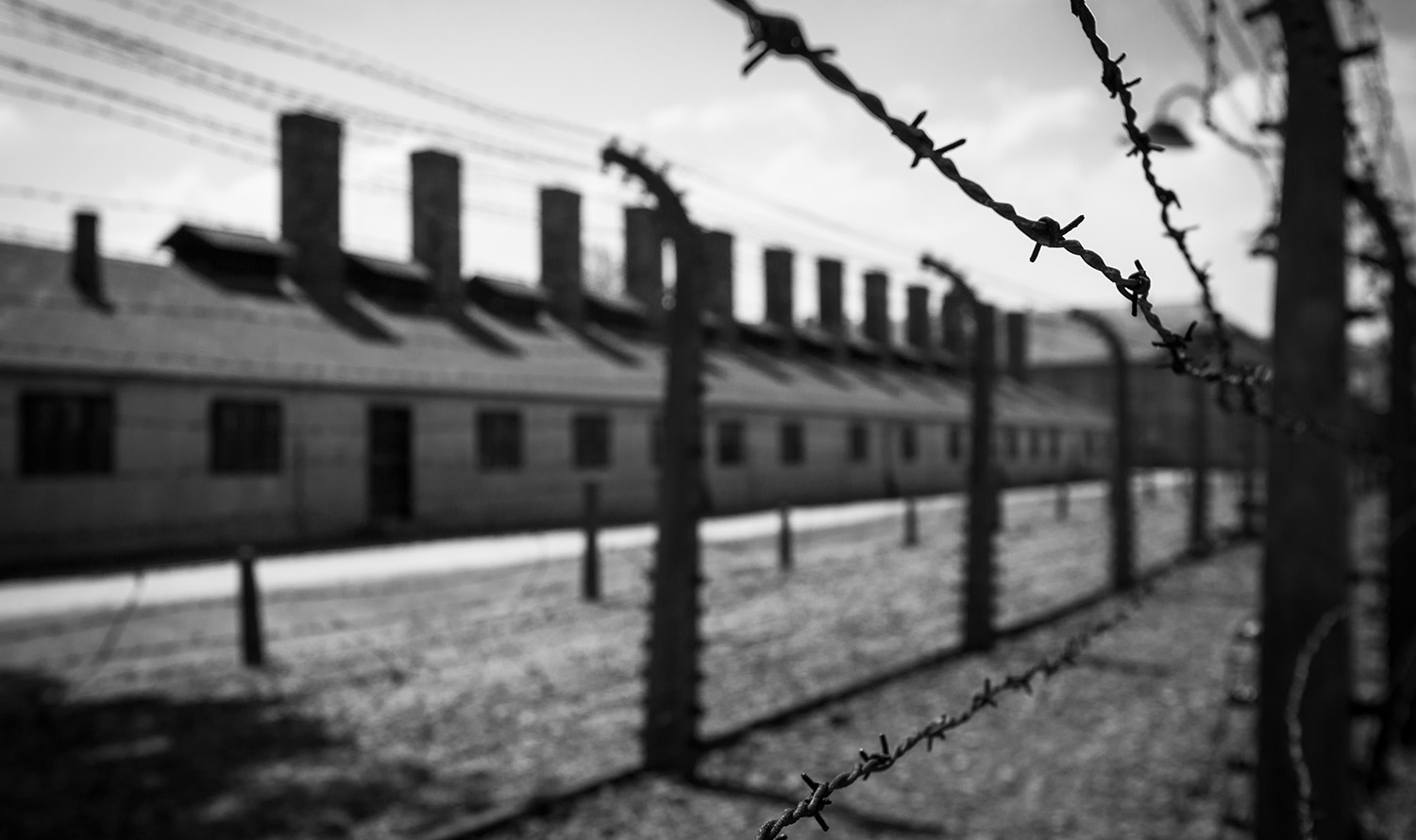 Fotografie alb-negru a unui lagăr de concentrare.