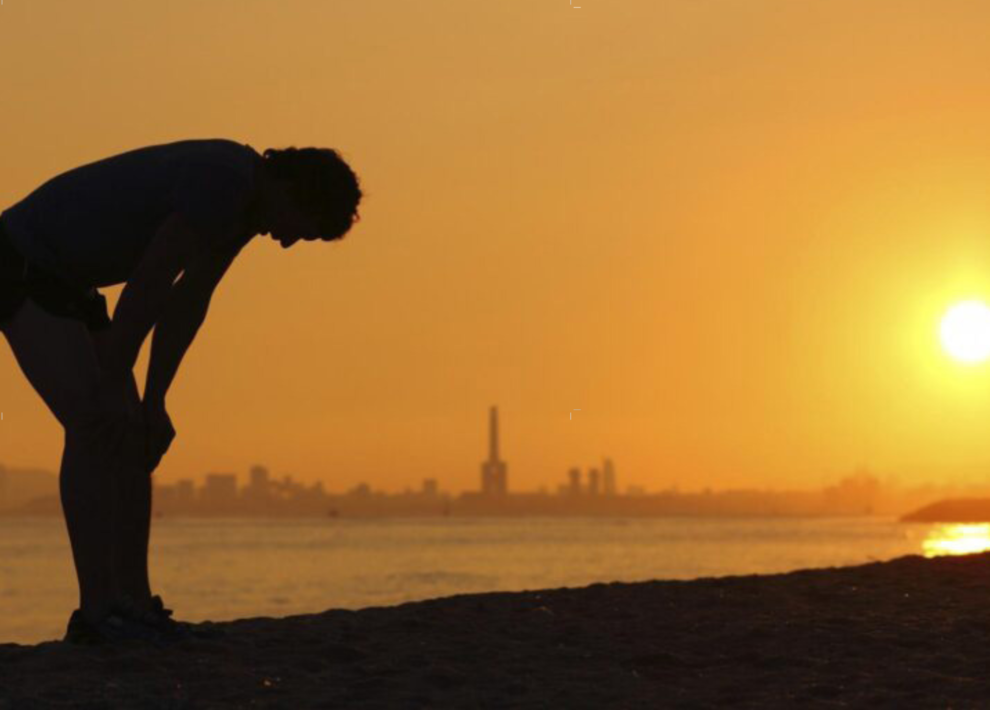 El hombre se para frente a la puesta de sol